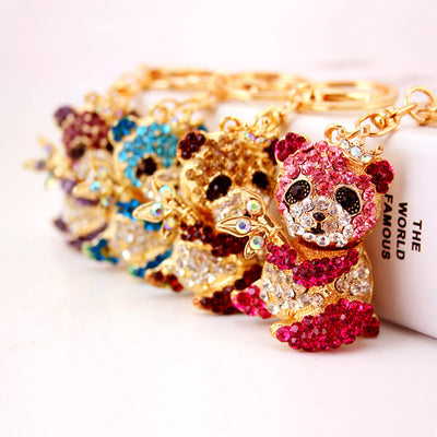 Four crowned panda keychains in pink, blue, coffee brown, and purple arranged in a row.