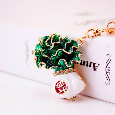 Close-up of a layered green cabbage charm with a white base and gold-tone edging.