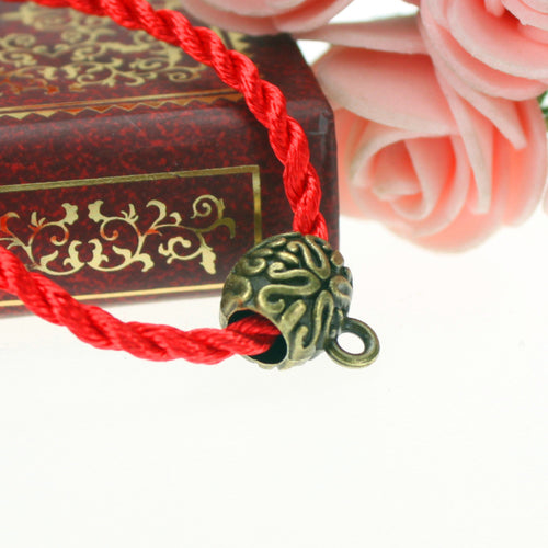 Second product image of the embossed large hole bail bead showing a rounded bail bead with embossed scrollwork and a han