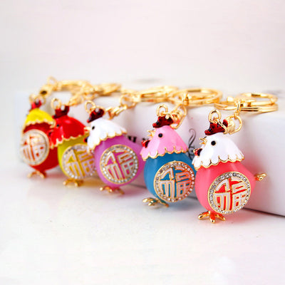 Five colorful chicken keychains arranged together on a white surface.