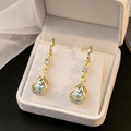 Elegant Gold Alloy Teardrop Huggie Earrings With Micro Pave Rhinestone Cat Eye Crystal Hollow Drop Earrings view 2