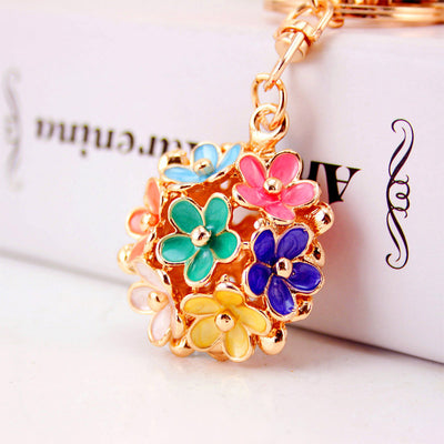 Close-up of a multicolor five-petal flower cluster charm in gold-tone metal.