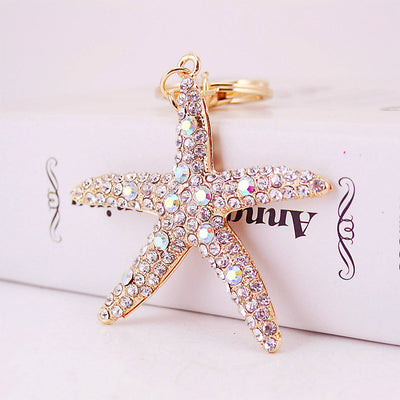 Front close-up of a gold tone starfish pendant covered with clear and iridescent stones.