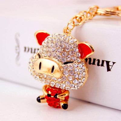 Close view of a red-eared pig figure covered in clear and red stones.