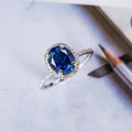 Deep Blue Oval Solitaire Halo Ring In Polished Silver Tone view 1