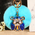 Jeweled Wealth Figure Keychains with Faux Fur Poms in Four Pictured Colors view 4
