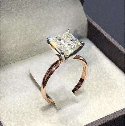 Rose-tone square clear solitaire ring in a box