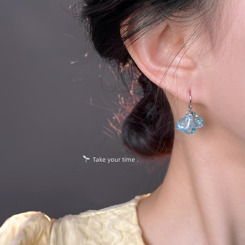 Silver-tone aqua translucent chip cluster hook earrings shown worn on an ear.