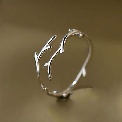Product view showing silver-tone textured branch open ring
