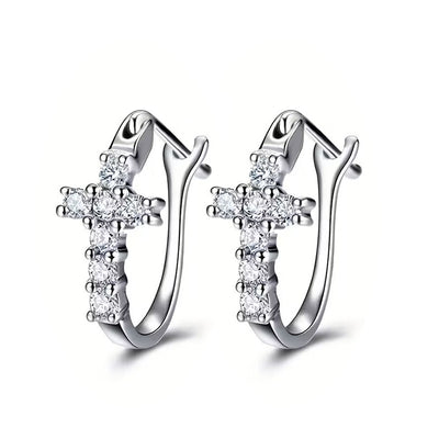 Product view showing cross clear-stone hinged hoop earrings in three metal tones