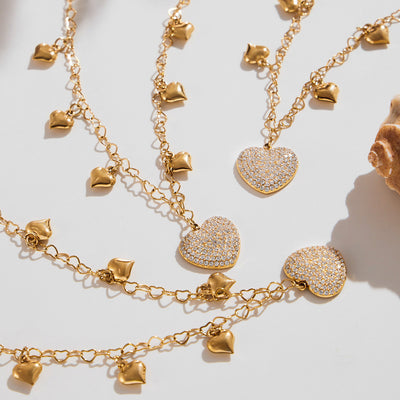 Gold heart link necklaces with pavé zircon heart pendants flat lay