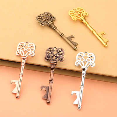 Five key-shaped bottle openers arranged on tan and peach surfaces.