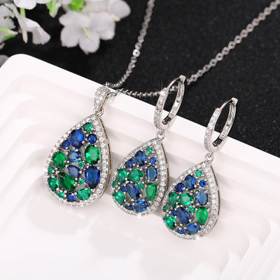 Product view showing blue and green teardrop cluster necklace and earring styles silver tone