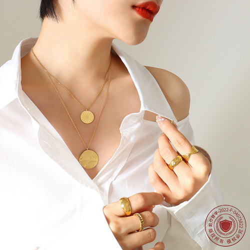 Gold layered disc pendants with rings and red lipstick crop