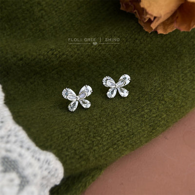 Silver-tone clear-stone open-loop ribbon bow studs in the first product display.
