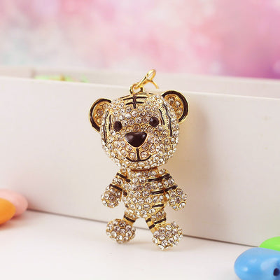 Front view of a clear rhinestone tiger charm with gold-tone outlines and dark facial details.