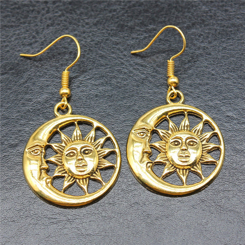 Styled view of sun and moon cutout drop earrings in two metal finishes