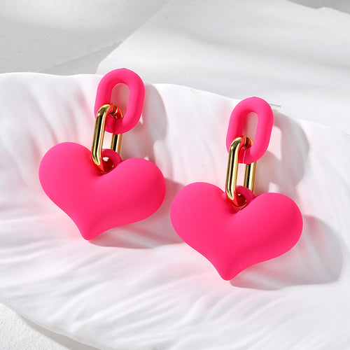 Pair of hot pink matte heart drop earrings on white shell tray