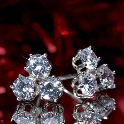 White metal three-stone triangle cluster studs on mirror red background