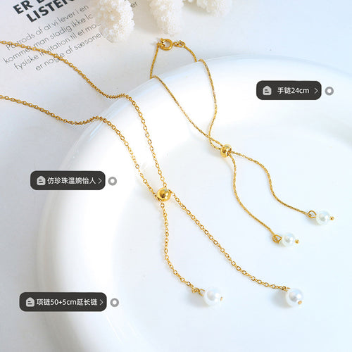 Gold pearl drop necklace and bracelet laid flat with length labels