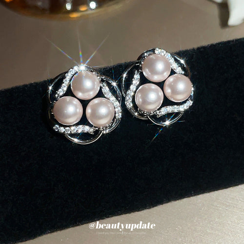 Rounded silver-tone floral forms set with pale pink pearl-like beads shown in a styled view.