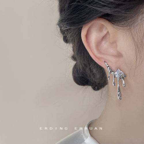 Silver liquid metal drip stud with square crystal worn on ear