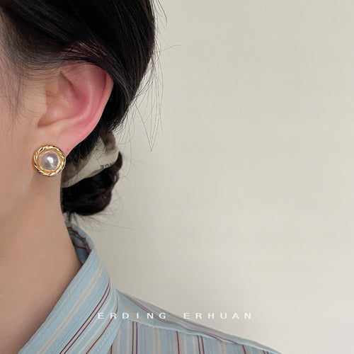 Gold pearl round stud worn on ear side view