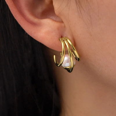 Gold triple band faux pearl stud earring worn on ear side view