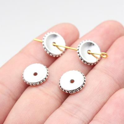 Antique Silver Smooth Disc Spacer Beads for Jewelry Making held in hand for scale