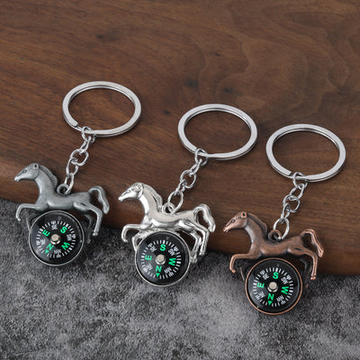 Three horse-shaped compass keychains in dark silver, bright silver, and copper finishes.