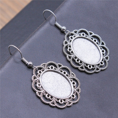 Close view of filigree oval bezel drop earrings in two antique finishes