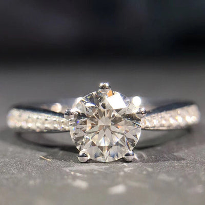 Silver round solitaire ring close-up four prong clear stone