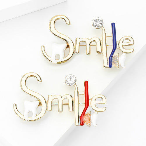 Angled display of the smile letter brooch on a white surface