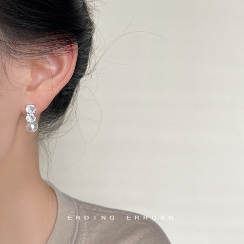 Pearl drop side of asymmetric studs worn on ear