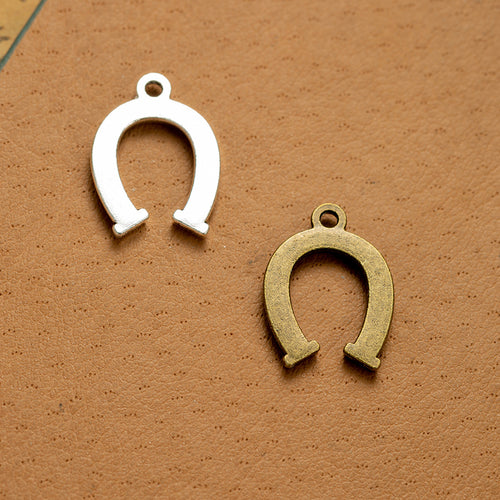 Second product image of the horseshoe charm showing an open horseshoe outline with recessed nail-hole details