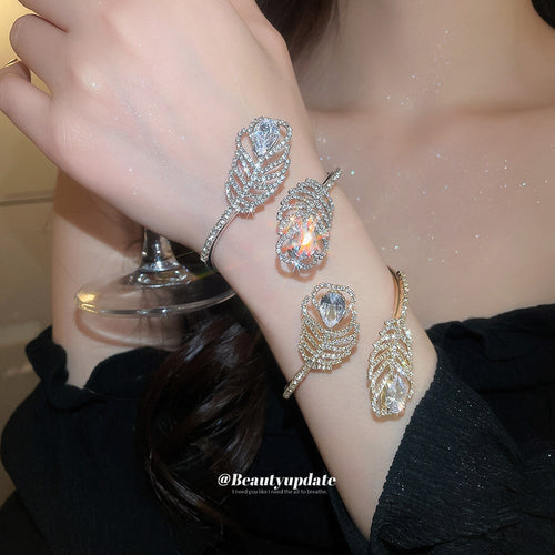 Silver and gold dual feather crystal open cuffs stacked on wrist
