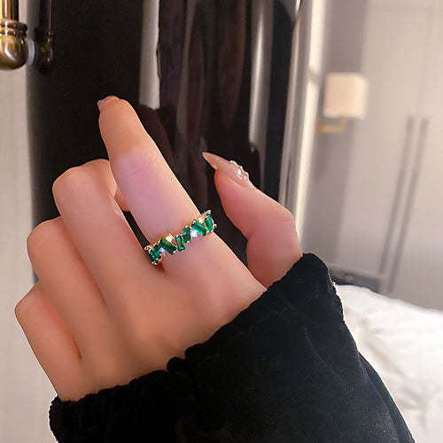 gold-tone ring encircled by green rectangular stones in a second styled product view