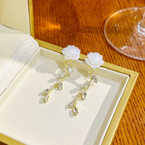 White rose vine drop earrings in open gold jewelry box