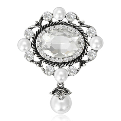 Silver tone oval crystal pearl drop brooch on white background