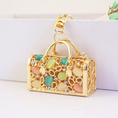 Close front view of the handbag-shaped charm with pastel oval accents.