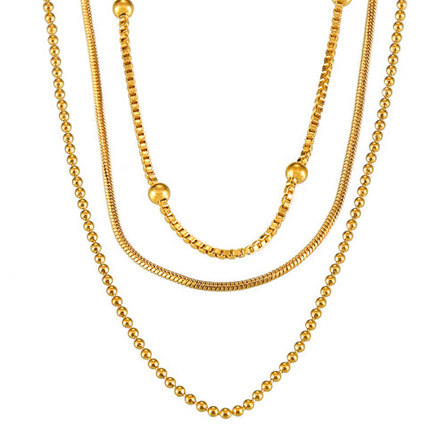 Gold snake, box, and ball-bead chains layered close-up white background