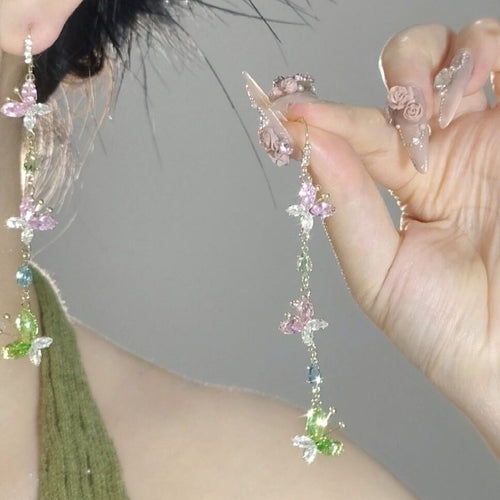 Long fine chains scattered with pastel crystals and butterfly charms in a close product view.
