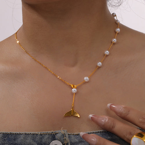 Gold pearl whale tail Y-necklace worn on a collarbone