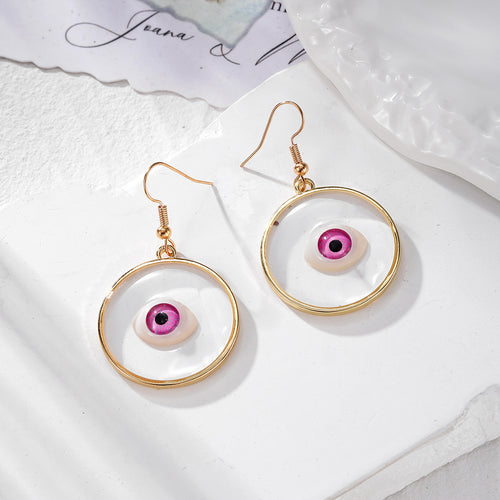 Pair of pink iris gold ring resin eyeball drop earrings on white stone