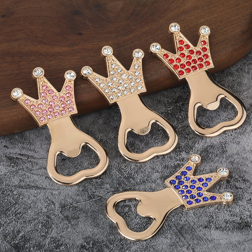 Four gold-tone crown bottle openers with pink, clear, red, and blue faceted accents.