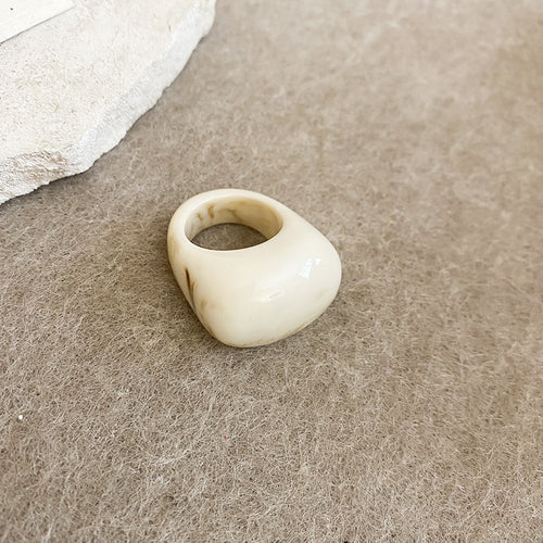 Cream beige marbled chunky resin ring on felt surface