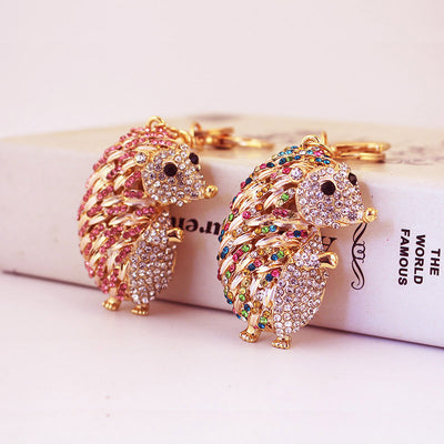 Two gold-tone hedgehog keychains with pink and multicolor rhinestone details.