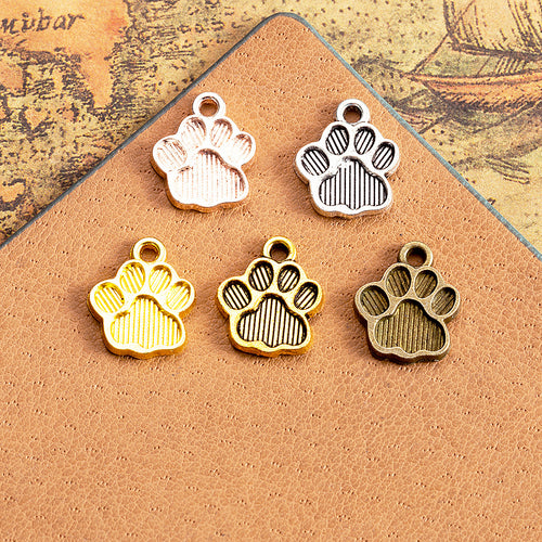 Striped Paw Print Metal Charm shown in grouped finish view