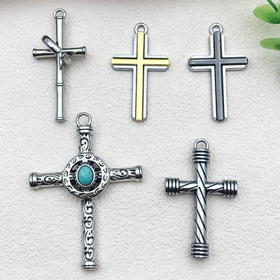 Antique silver cross charms arranged on a light background