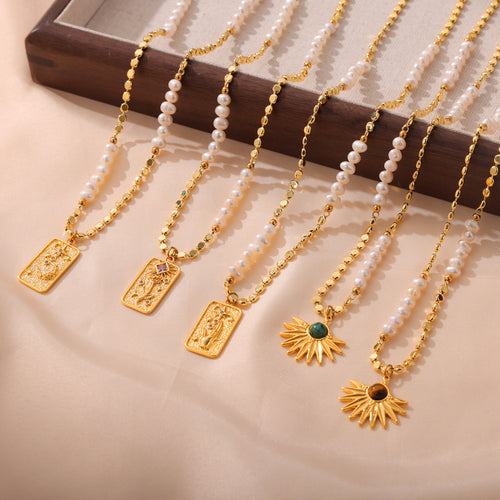 Five gold pearl disc chain necklaces with rose hand star and sun pendants laid out